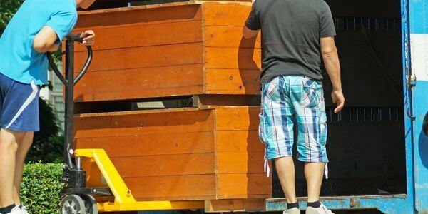 Möbellift Cottbus: Zwei Helfer tragen einen Holzschrank aus einem Lkw