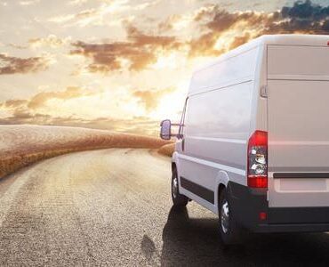 Weißer Transporter auf einer Straße im Abendlicht – Transporter für den Umzug